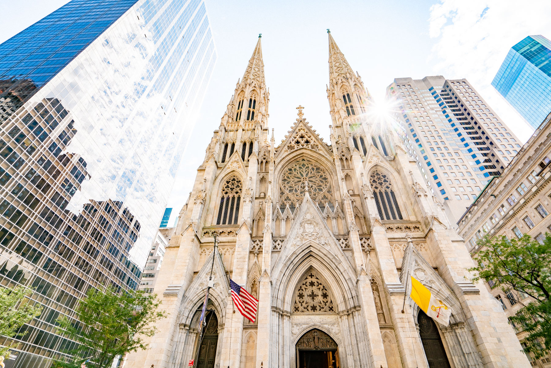 St. Patrick's Cathedral's twin spires rise between glass skyscrapers on Fifth Avenue.