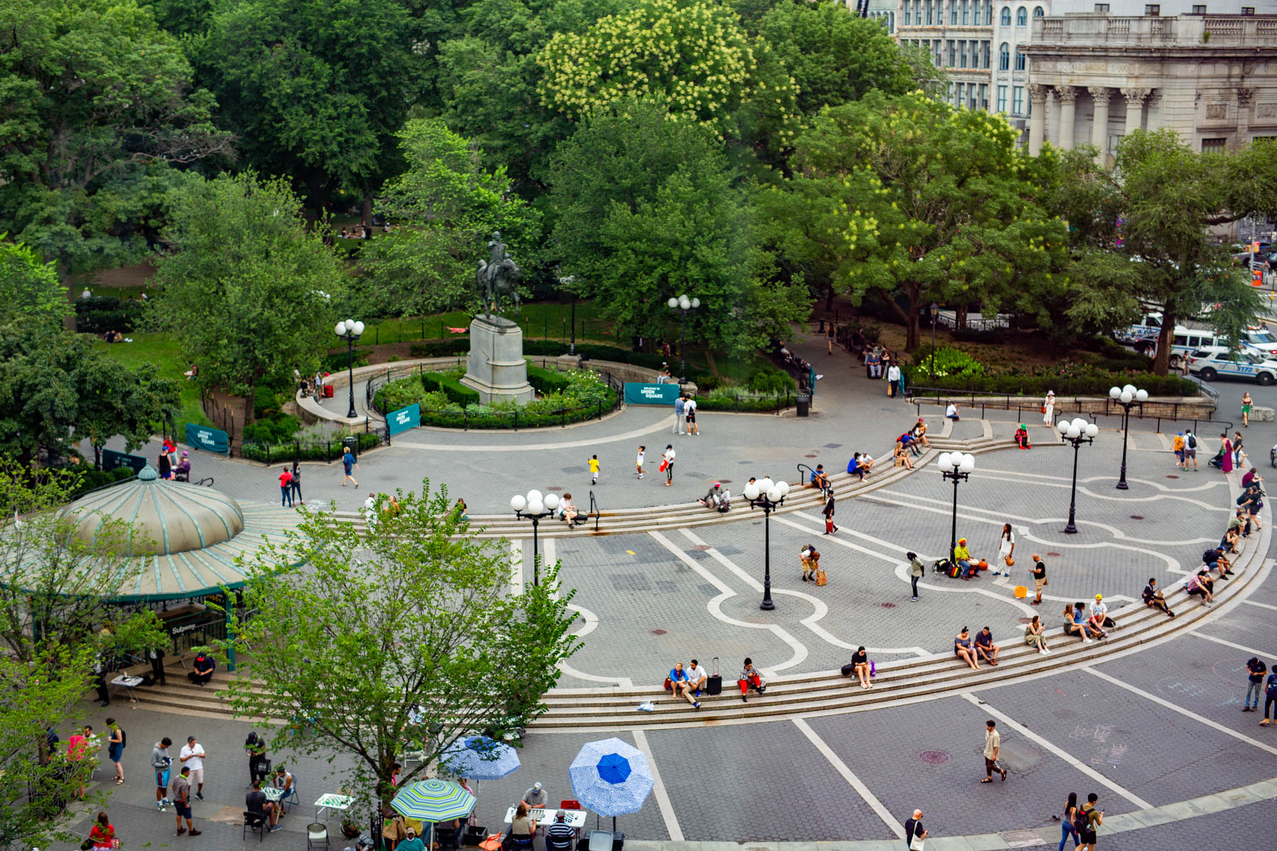 An aerial view overlooks Union Square Park with people gathered near a statue and steps.