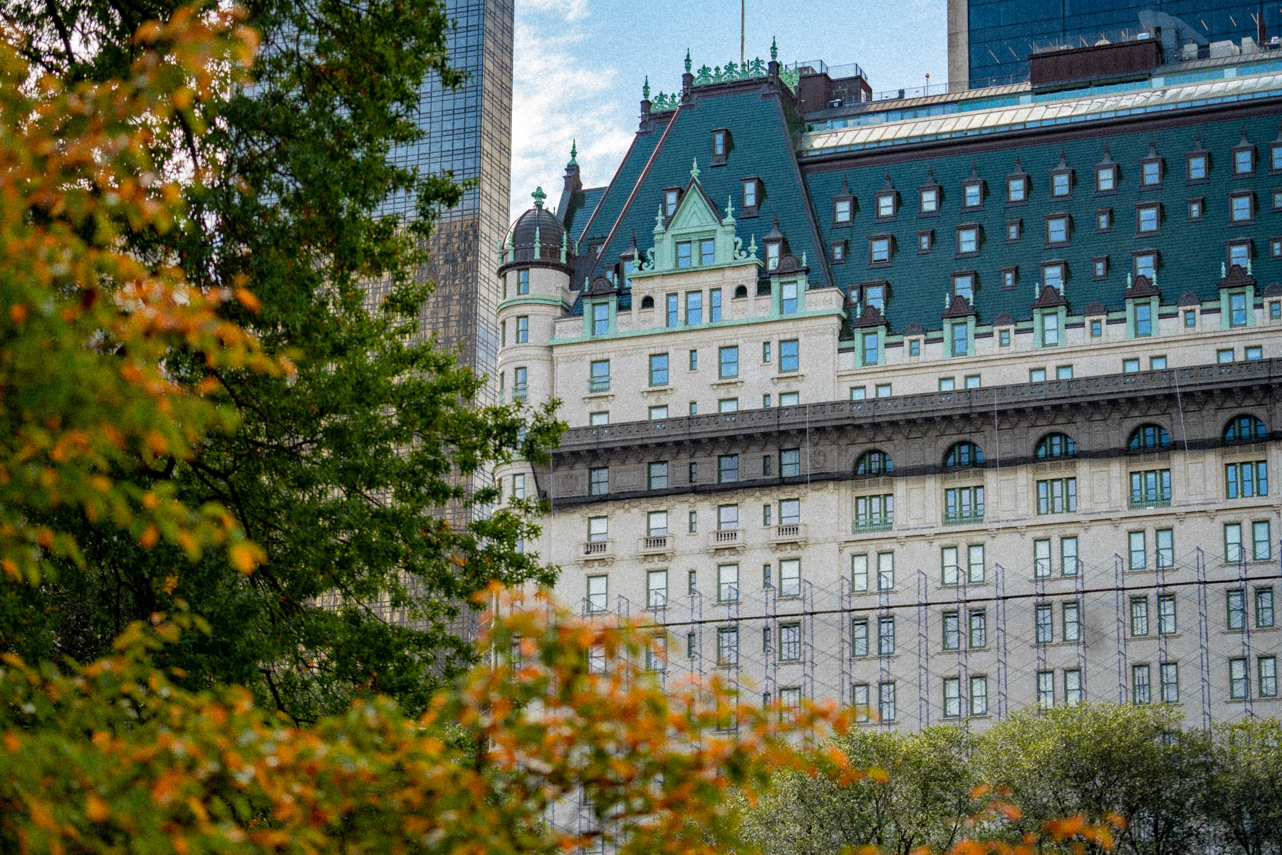 The Plaza Hotel's mansard roof rises above autumn foliage in Central Park.