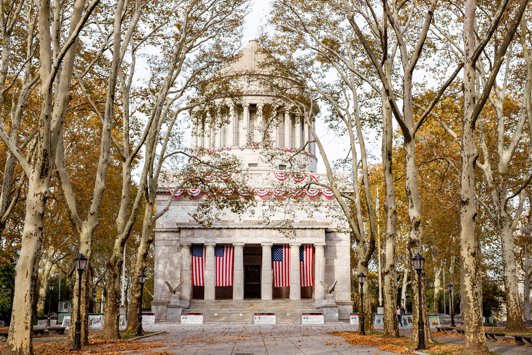 Grant's Tomb is framed by bare autumn trees and decorated with American flags and bunting.