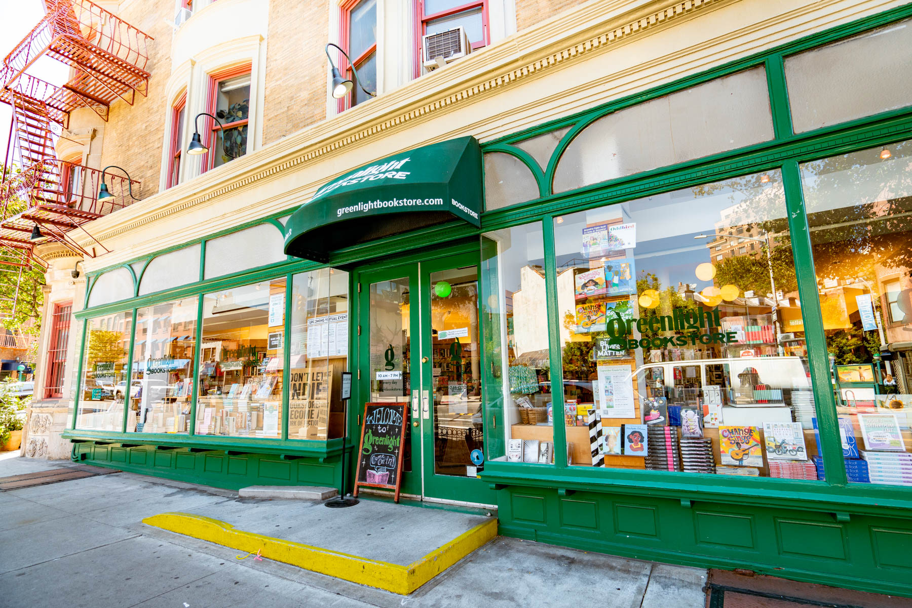 The green storefront of Greenlight Bookstore on a Brooklyn street corner.