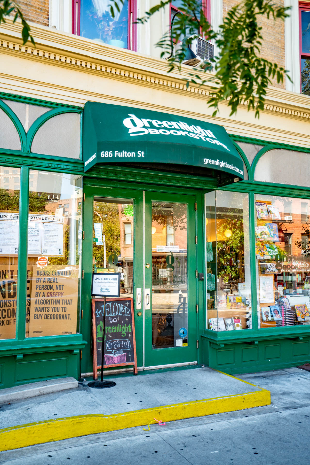 The green storefront and awning of Greenlight Bookstore on Fulton Street.