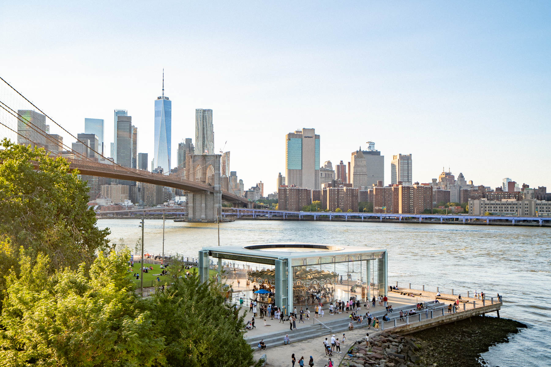 A view from Brooklyn Heights shows the Manhattan skyline, Brooklyn Bridge, and Jane's Carousel by the East River.