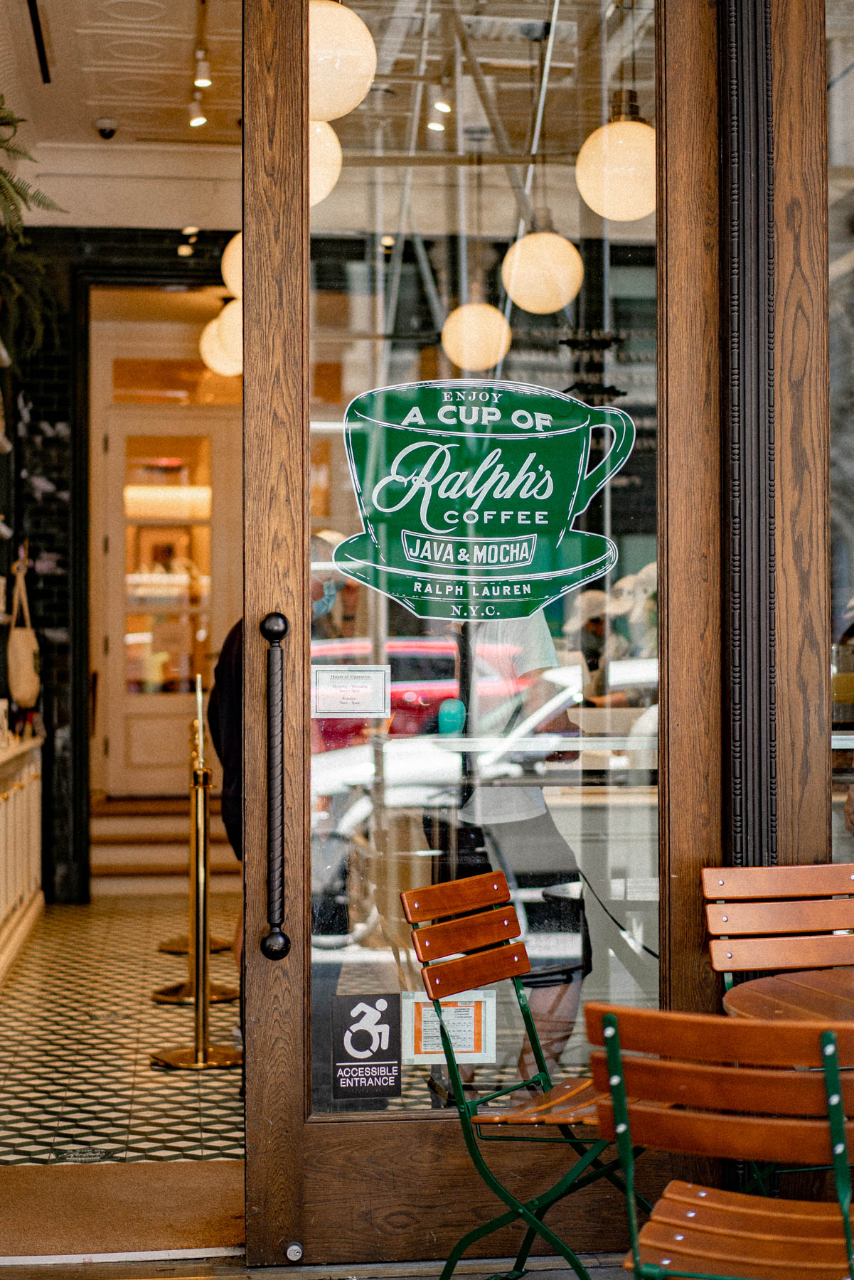 A glass door with a Ralph's Coffee logo decal at a Ralph Lauren storefront in the West Village.