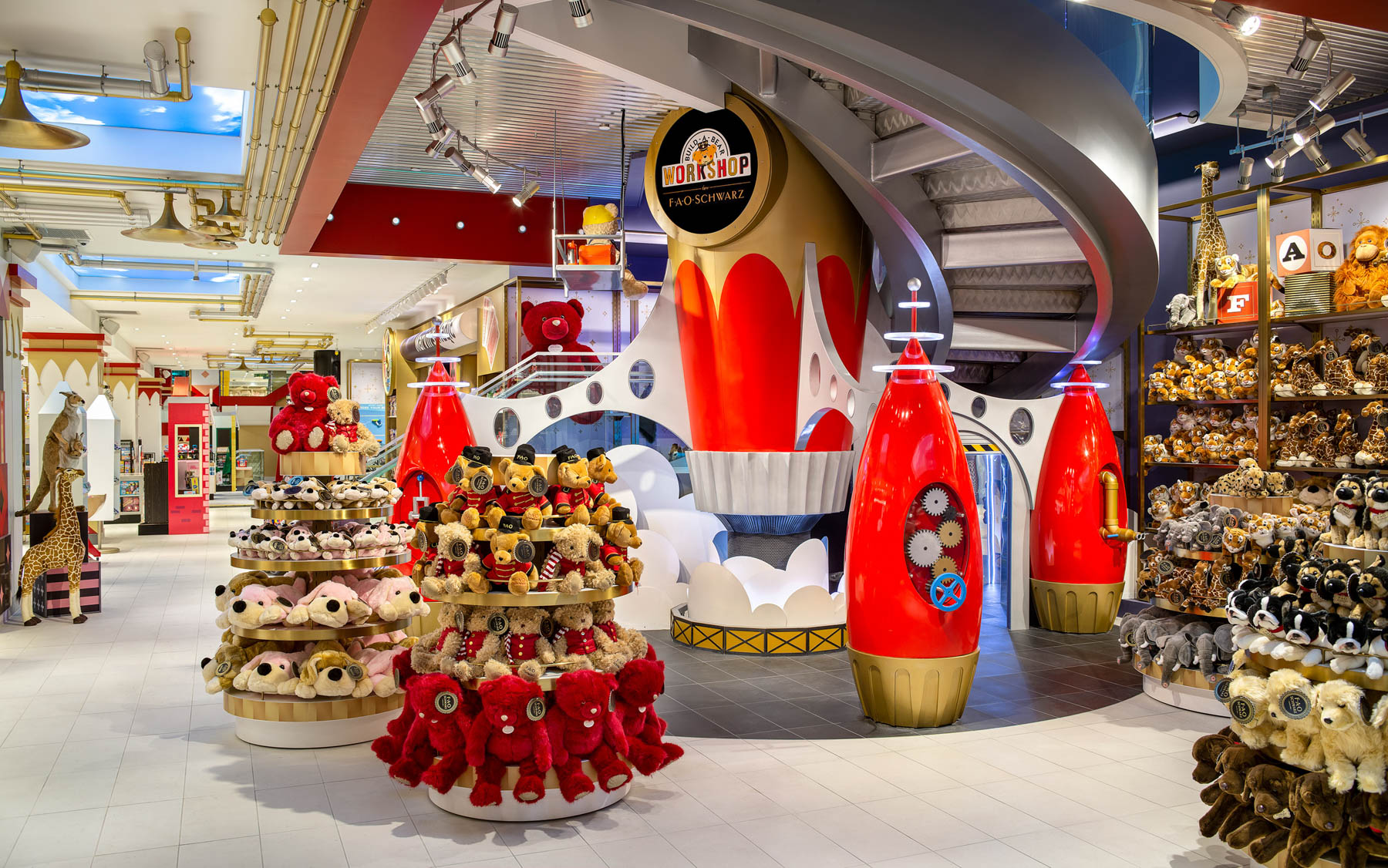 The interior of FAO Schwarz toy store shows teddy bear displays and a whimsical workshop facade.