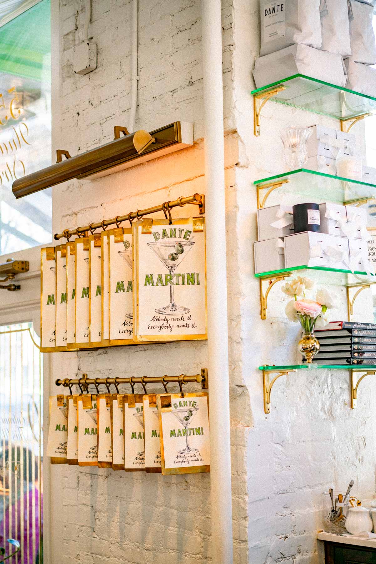 Menus and merchandise hang on a shelf inside Caffe Dante, a West Village cafe.