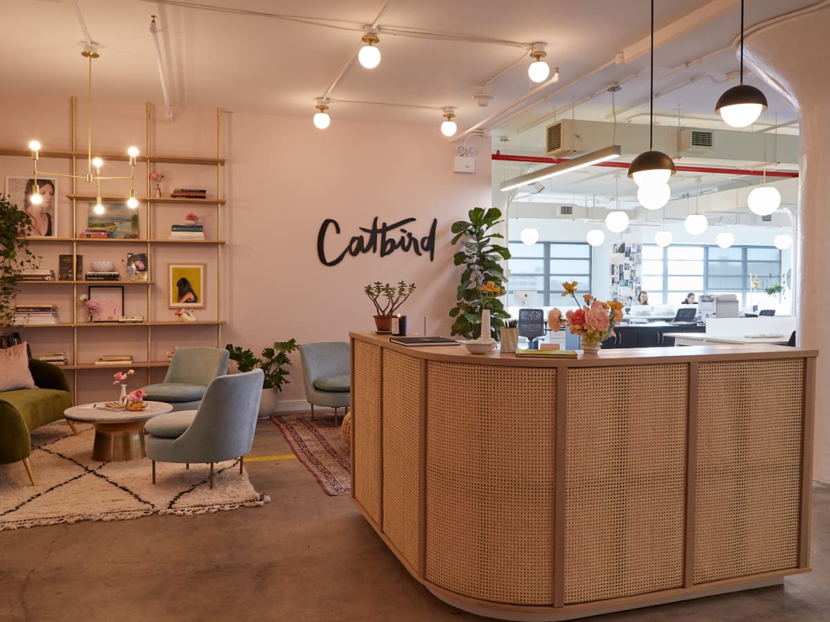 An interior view of a boutique reception area with a Catbird sign on the wall.