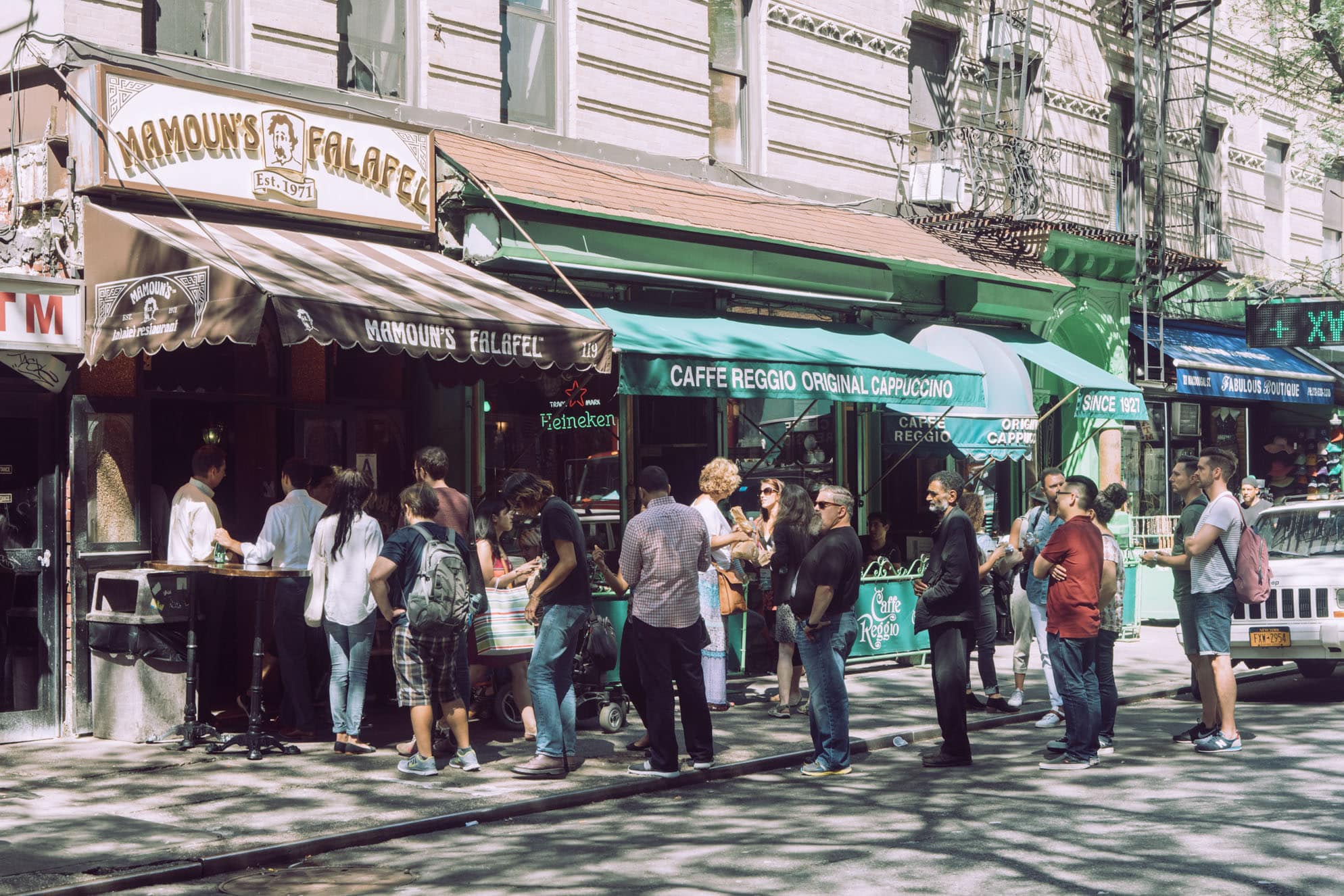 A crowd gathers on the sidewalk outside Mamoun's Falafel and Caffe Reggio in Greenwich Village.