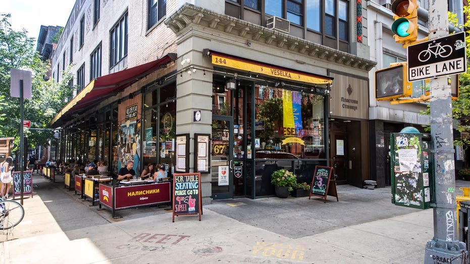 The corner storefront of Veselka restaurant with outdoor seating on a city street.