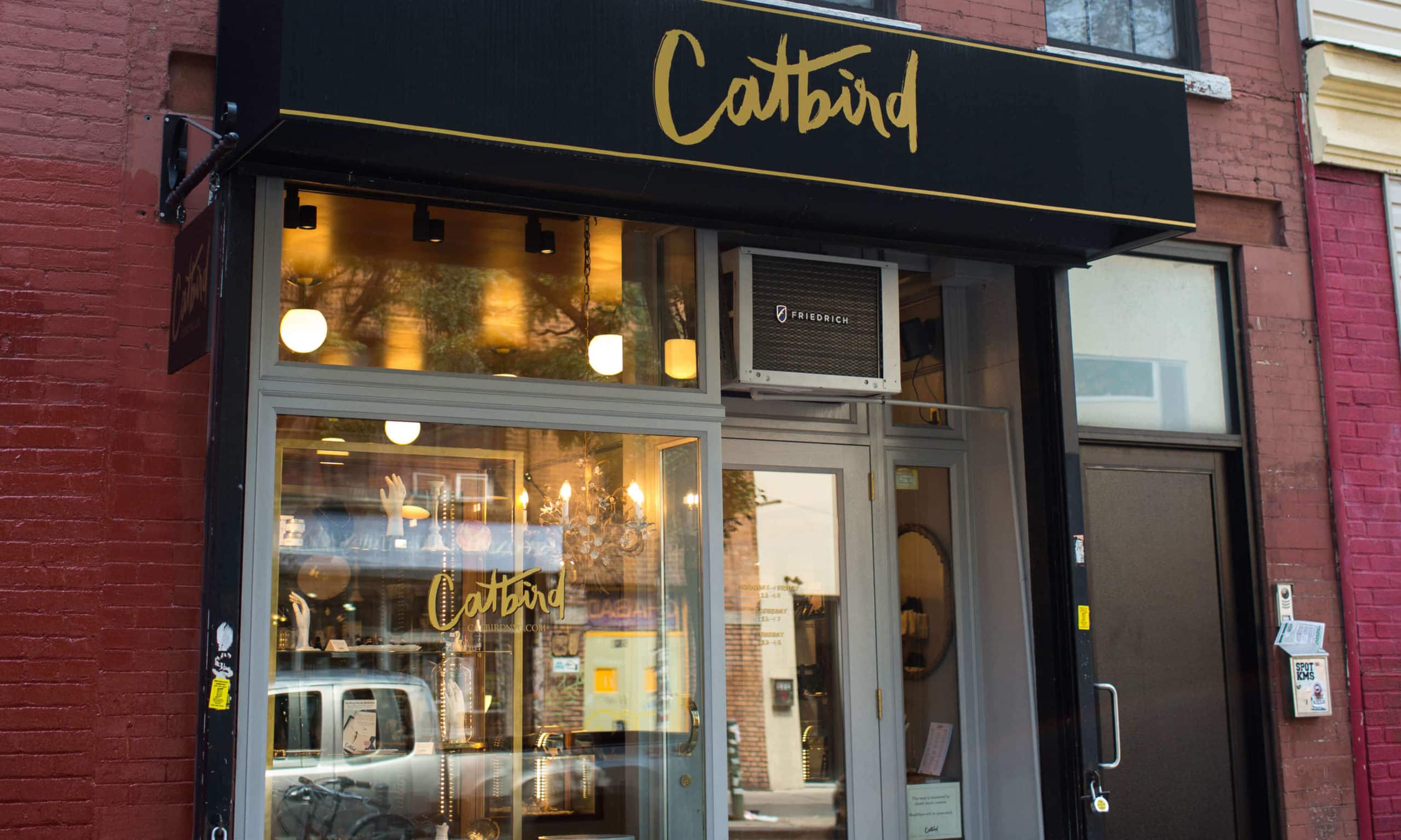 A storefront with a black and gold Catbird sign above the entrance.