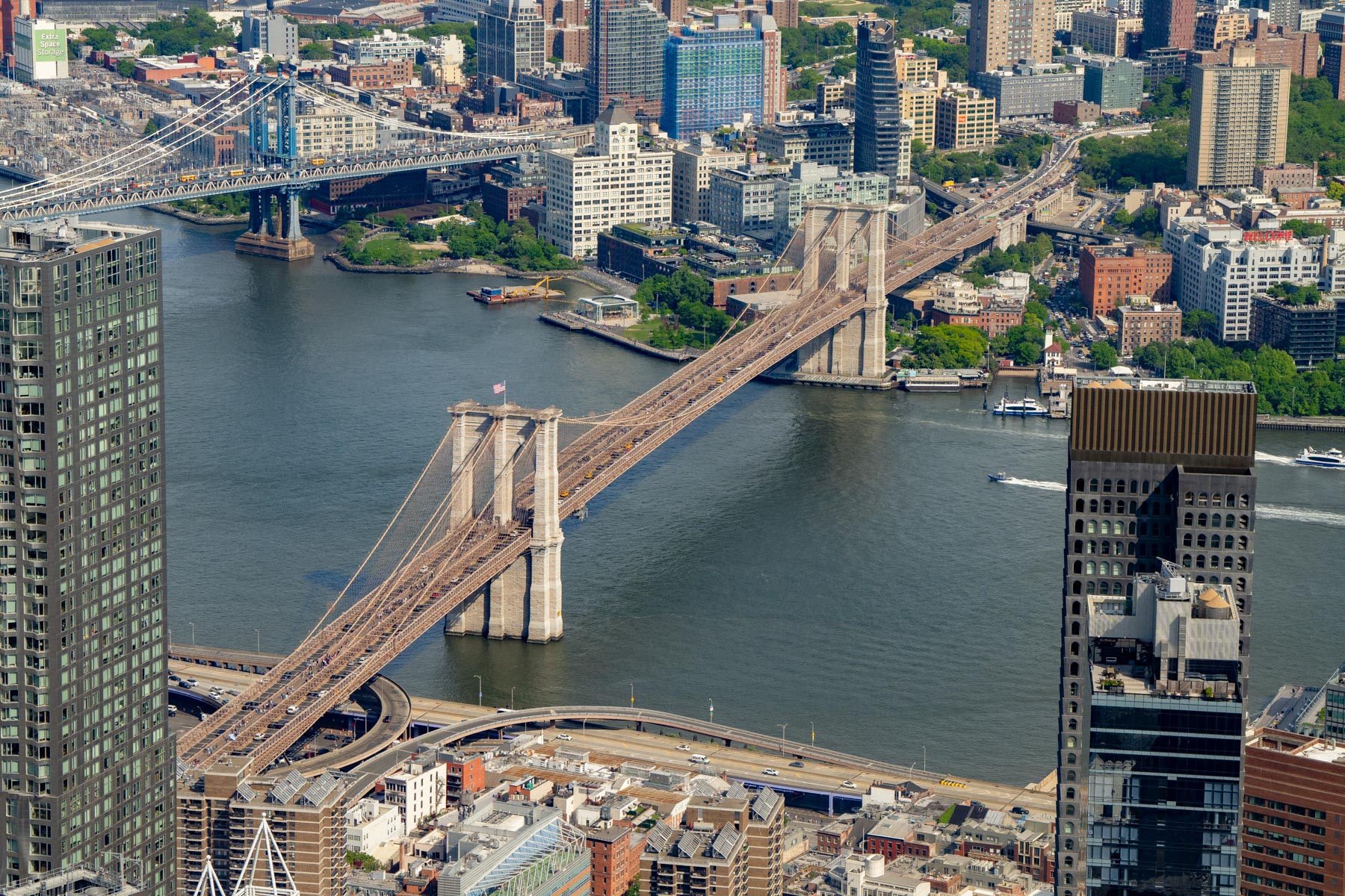 An aerial view from One World Trade Center overlooks the Brooklyn Bridge, Manhattan Bridge, and the East River.