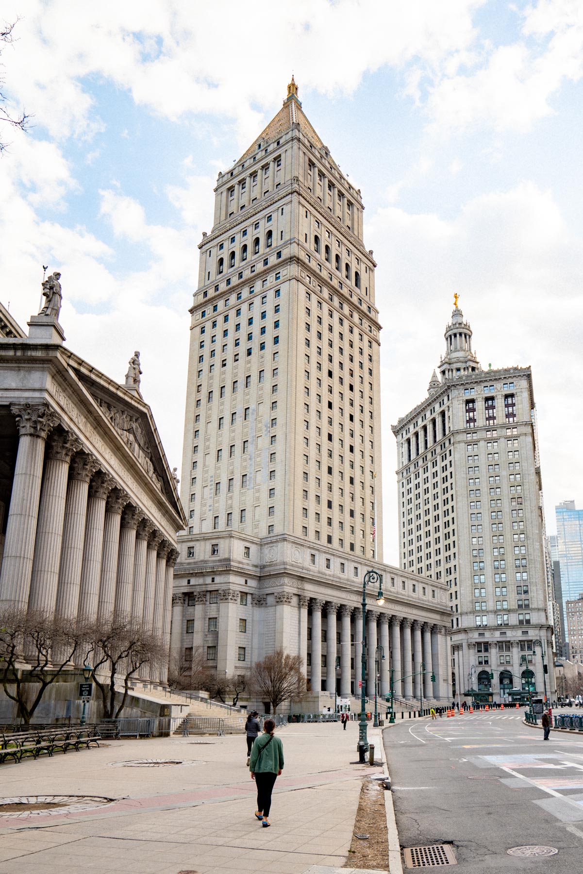 A person walks near the Thurgood Marshall United States Courthouse and Manhattan Municipal Building in the Financial District.