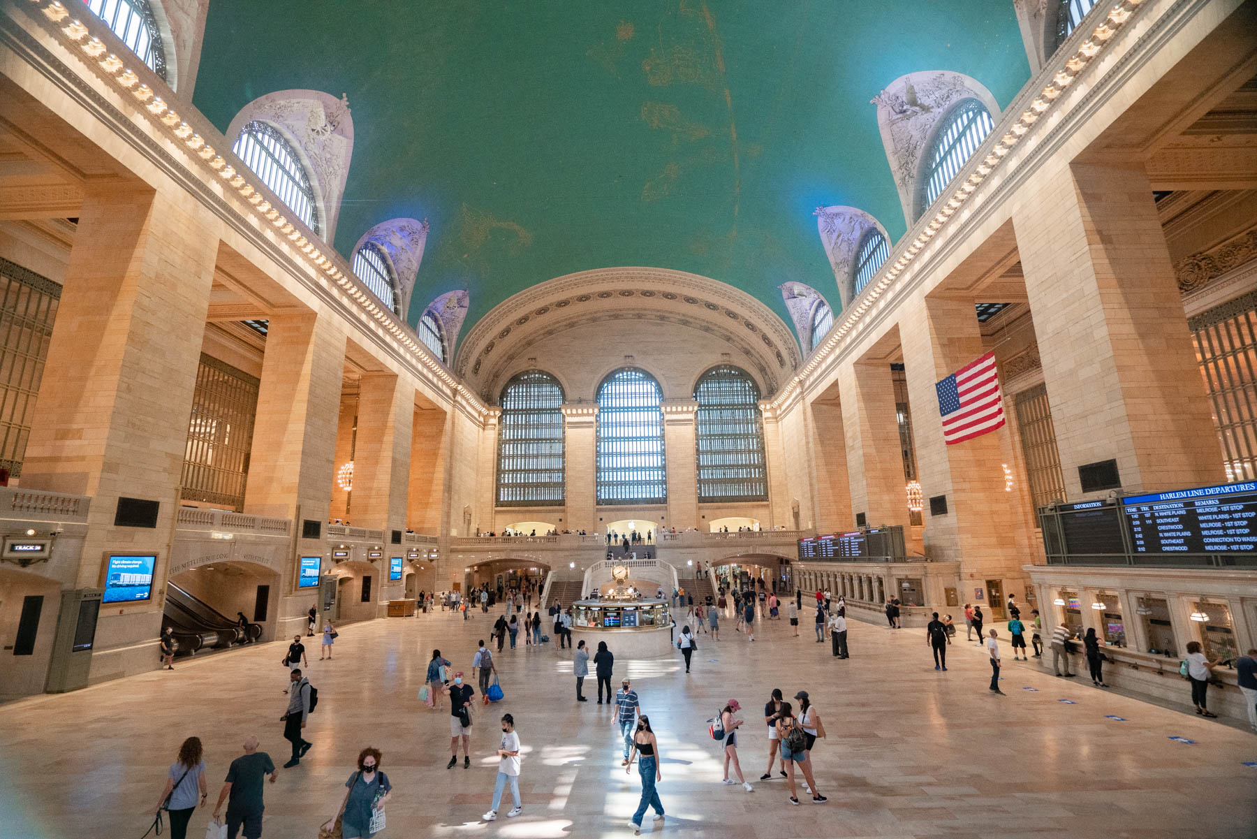 Travelers and visitors walk through the main concourse of Grand Central Terminal beneath its celestial ceiling.