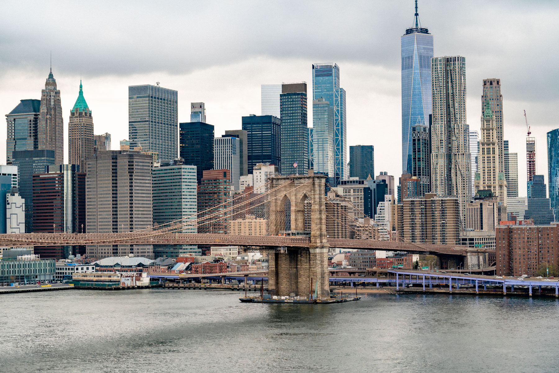The Brooklyn Bridge spans the East River in front of the Lower Manhattan skyline.