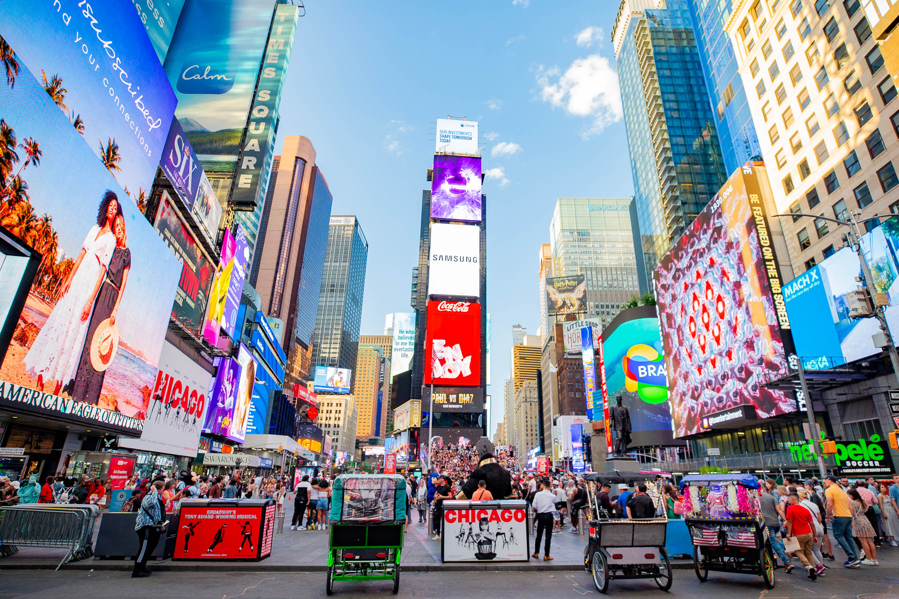 Crowds and billboards fill Times Square during the day.