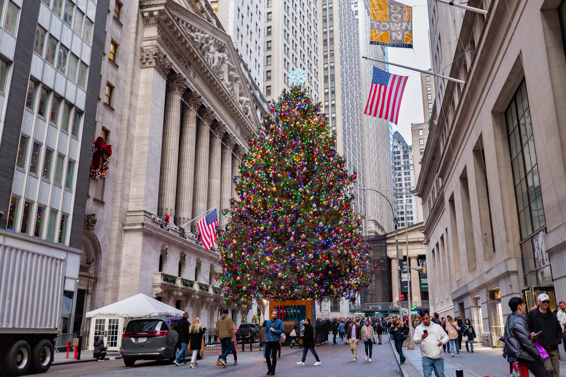 A large decorated Christmas tree stands on Wall Street in front of the New York Stock Exchange.
