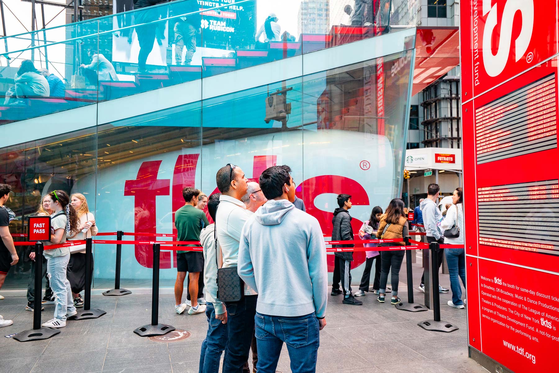 Tourists line up outside the red TKTS ticket booth in Times Square.