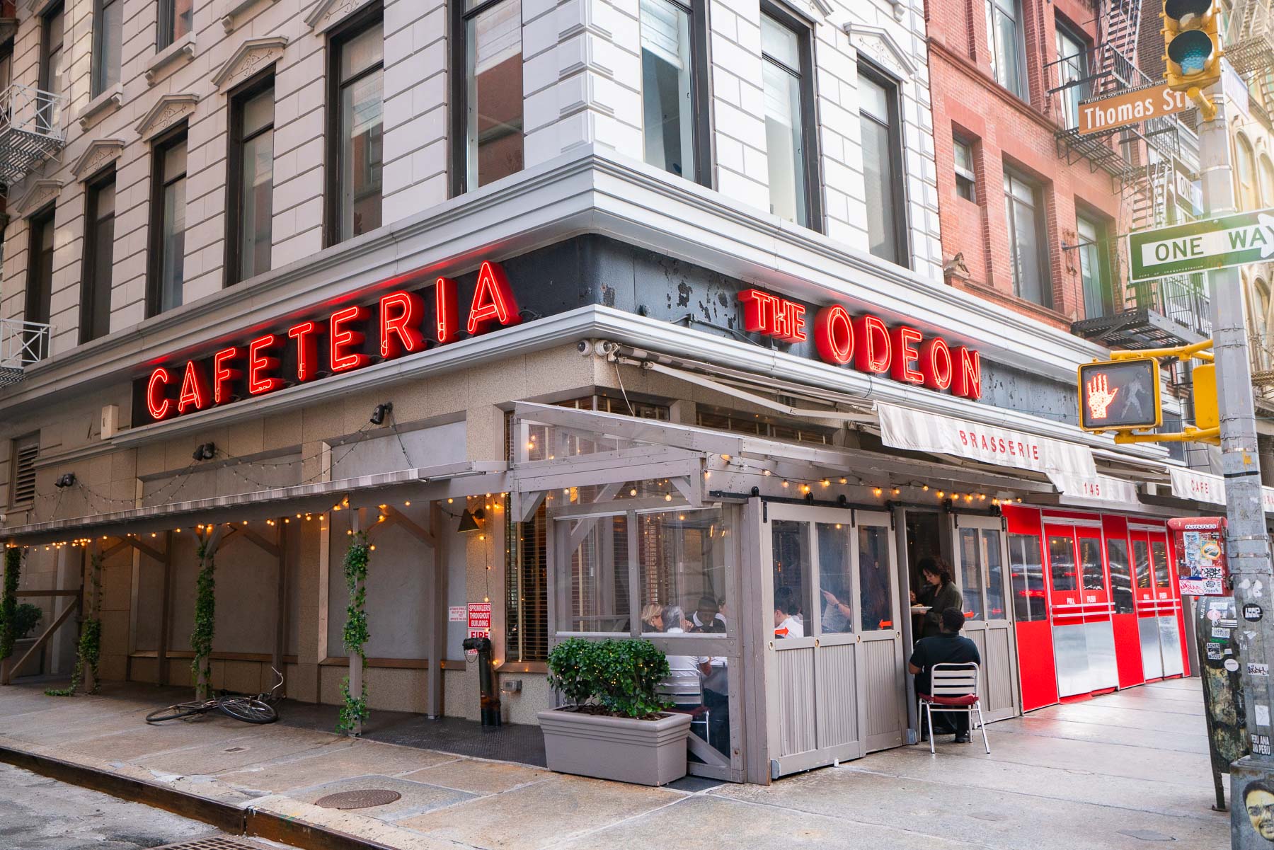 The Odeon restaurant storefront with neon signage on a Tribeca corner