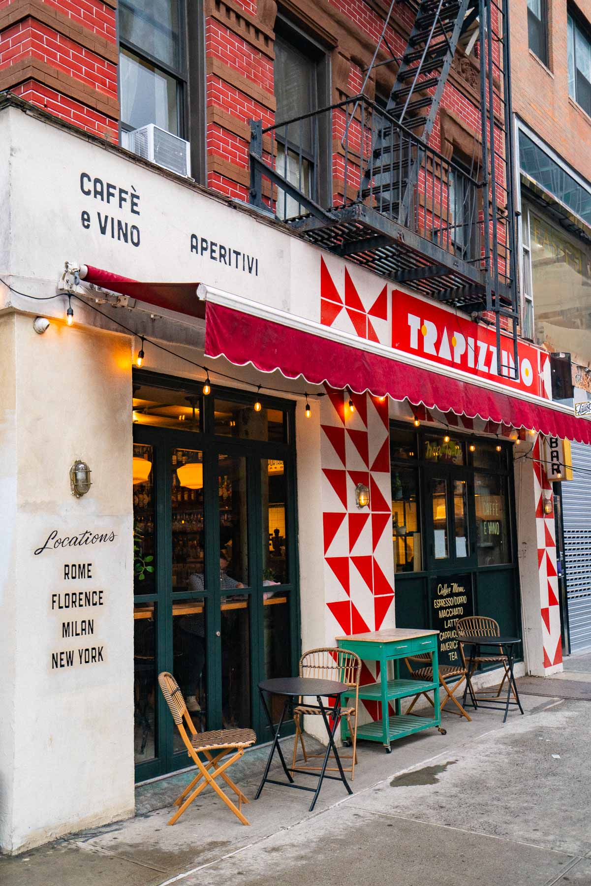 Storefront of the Trapizzino restaurant with red and white tiled facade and outdoor seating on the Lower East Side.