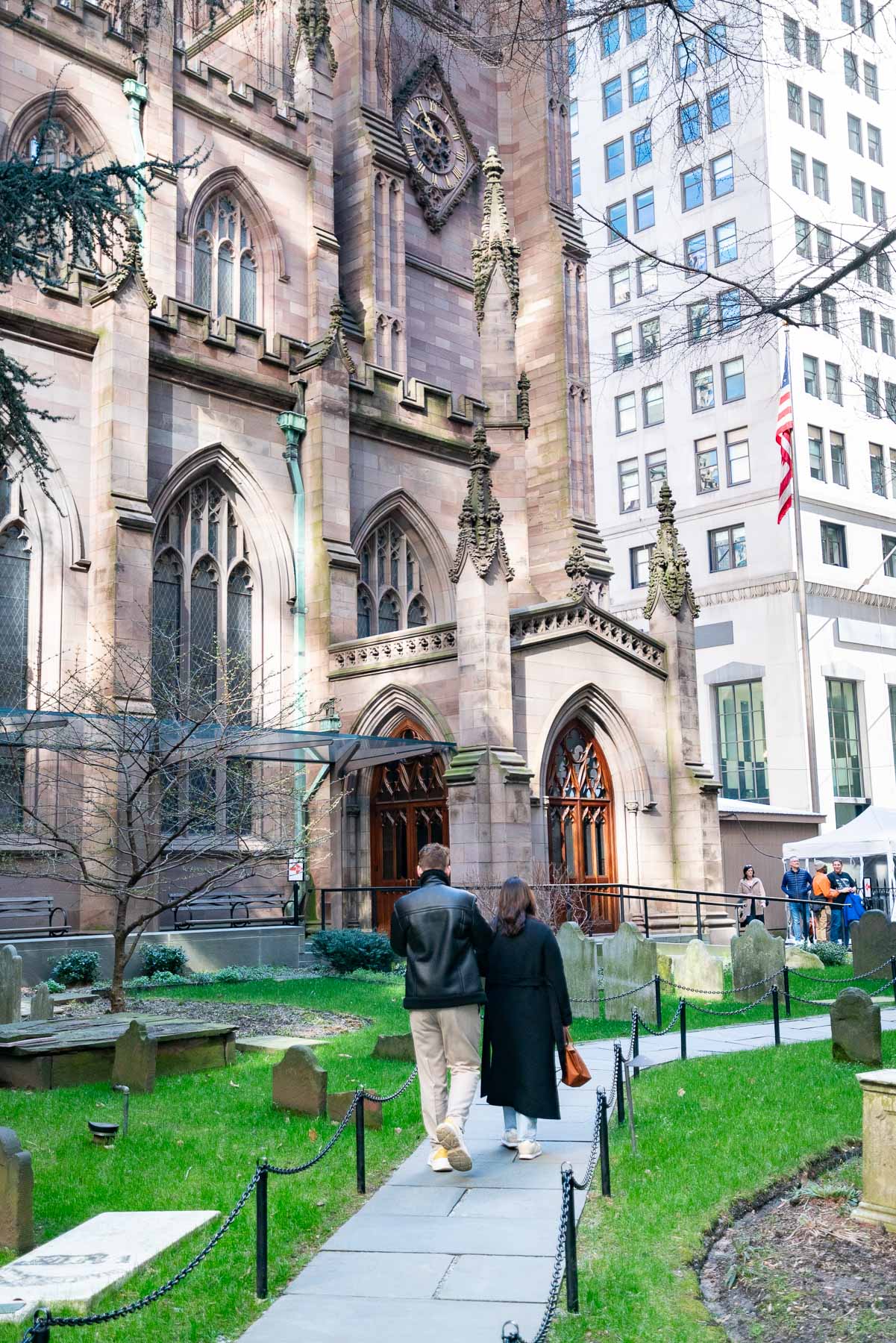 A couple walks through the churchyard cemetery beside Trinity Church in Lower Manhattan.