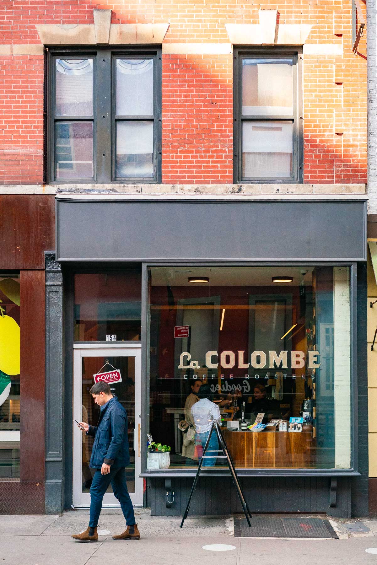 A man walks past the La Colombe Coffee Roasters storefront in a brick building in SoHo.