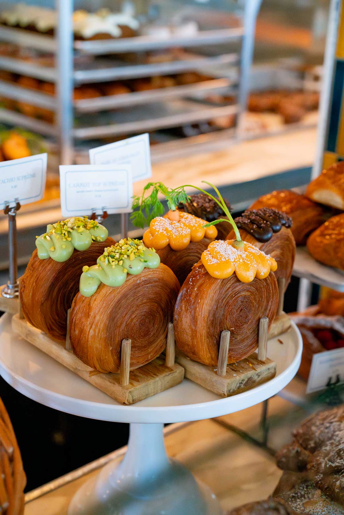 Display of pistachio, orange, and chocolate circle croissants at Lafayette, one of the best bakeries in Soho