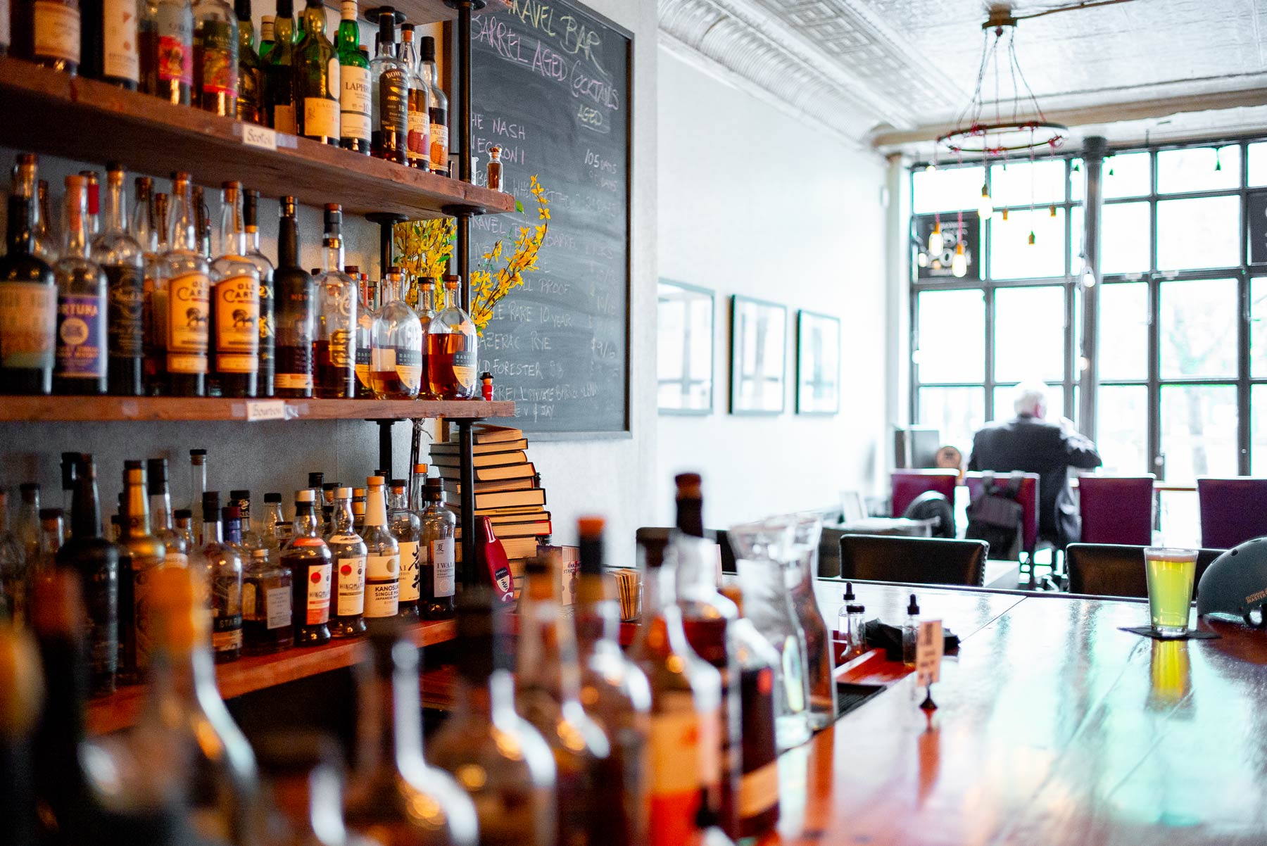 Rows of whiskey and bourbon bottles line the bar at Travel Bar in Brooklyn.