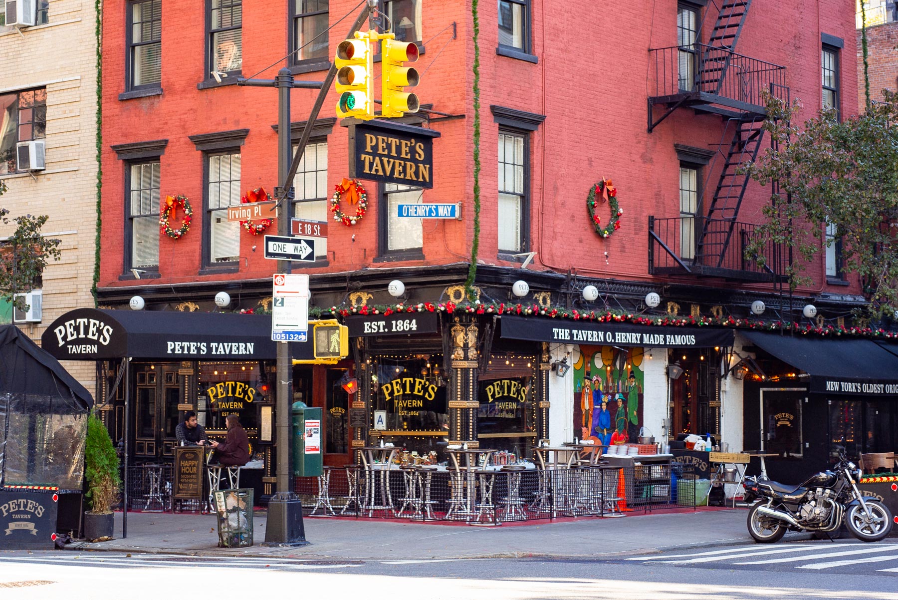 A street corner view of Pete's Tavern decorated with holiday wreaths on Irving Place.