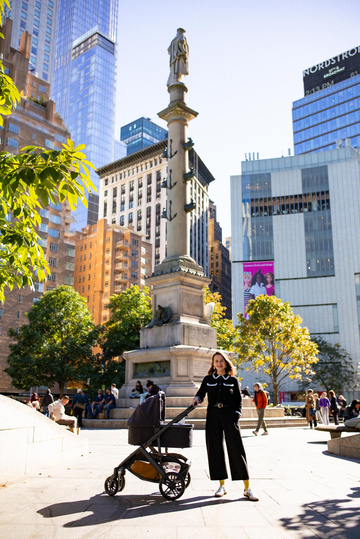 Mom and child in a stroller at Columbus Circle in the fall 