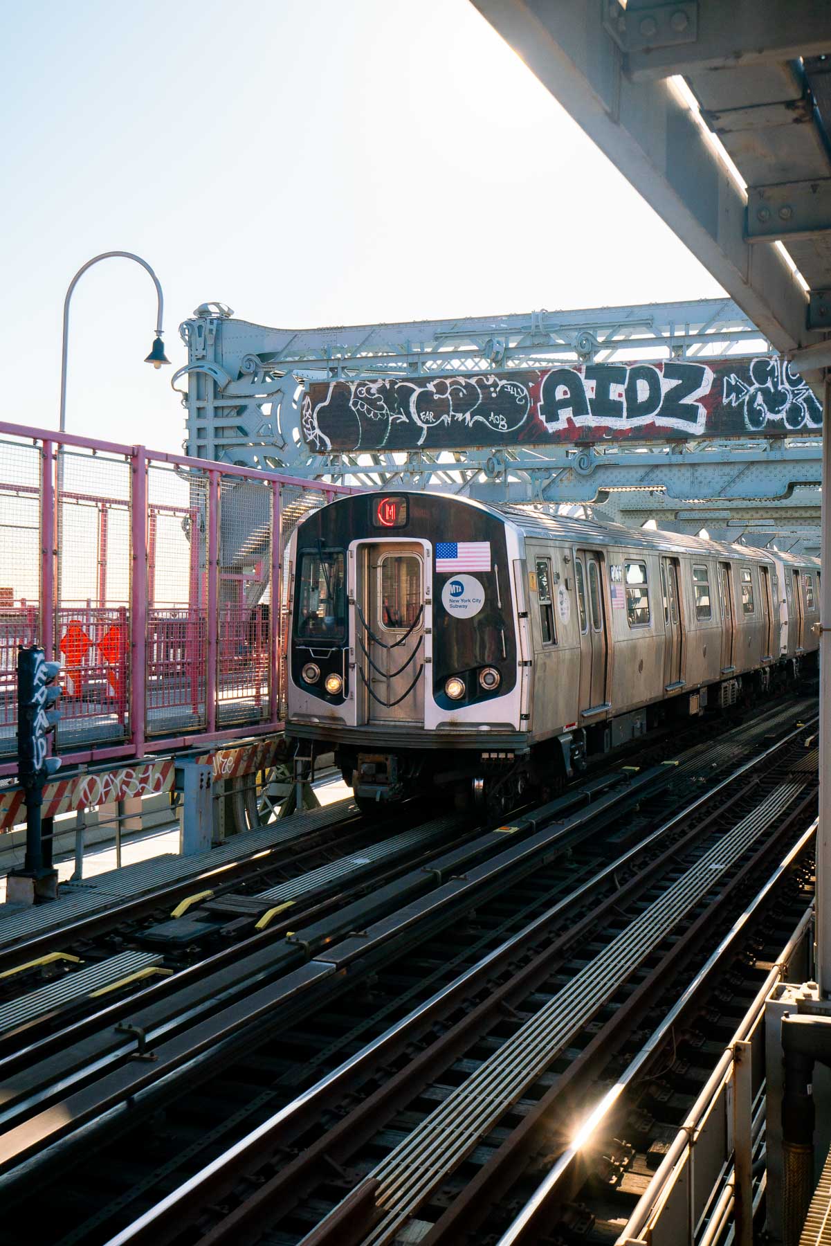 A B or Q subway train crossing the Manhattan Bridge over the East River with the city skyline in the background